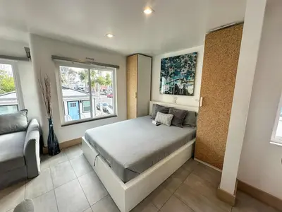 a bedroom with a large bed and a couch at Mission Beach Loft Garage Steps 2 Ocean in San Diego