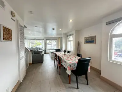 a dining room with a table and chairs and a couch at Mission Beach Loft Garage Steps 2 Ocean in San Diego