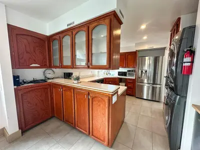 a kitchen with wooden cabinets and stainless steel appliances at Mission Beach Loft Garage Steps 2 Ocean in San Diego