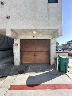 a garage with a brown garage door and a trash can at Mission Beach Loft Garage Steps 2 Ocean in San Diego
