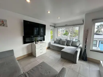 a living room with a couch and a flat screen tv at Entire Mission Beach Duplex Steps 2 the Ocean & Bay 2 Parking Spots in San Diego