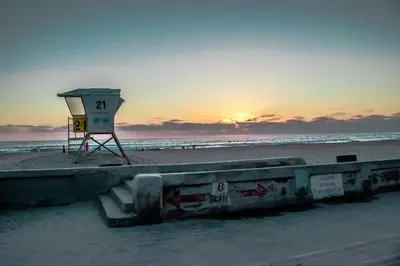 a lifeguard tower on the beach at sunset at Entire Mission Beach Duplex Steps 2 the Ocean & Bay 2 Parking Spots in San Diego