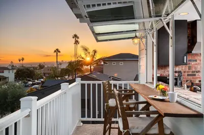 a porch with a wooden table and chairs on a balcony at Stay & Play Pacific Beach Compound in San Diego