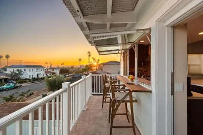 a balcony with a table and chairs overlooking a street at Stay & Play Pacific Beach Compound in San Diego
