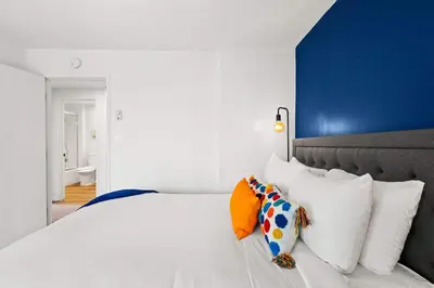 a bedroom with a large white bed with white pillows at Ocean front luxury condo with sunset views in San Diego
