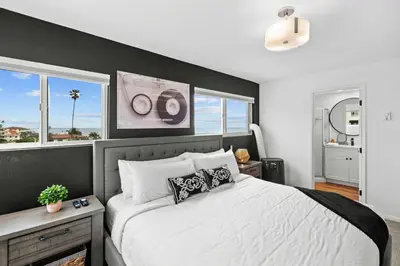 a bedroom with a large bed with a black accent wall at Ocean front luxury condo with sunset views in San Diego