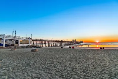 a view of a beach with a pier at sunset at 5N-31 Beach View BBQ & Jacuzzi in Oceanside