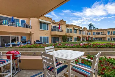 a patio with a table and chairs in front of a building at 5N-31 Beach View BBQ & Jacuzzi in Oceanside