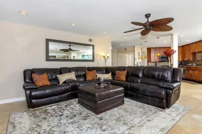 a leather couch in a living room with a ceiling fan at 5N-53 Beach Bliss Ocean Views in Oceanside