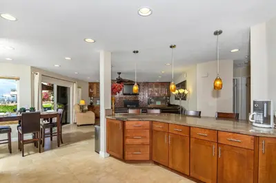 a kitchen with wooden cabinets and a dining room at 5N-53 Beach Bliss Ocean Views in Oceanside