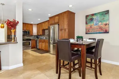 a kitchen with a wooden table and a refrigerator at 5N-53 Beach Bliss Ocean Views in Oceanside