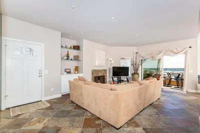 a living room with a large couch and a fireplace at 5N-64 Beachfront On the Strand in Oceanside