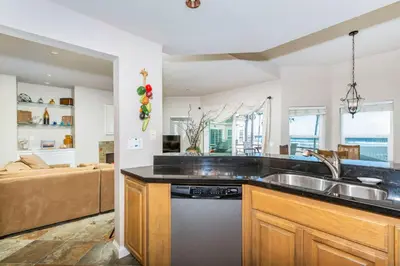 a kitchen with a sink and a couch at 5N-64 Beachfront On the Strand in Oceanside