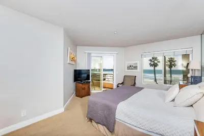 a bedroom with a bed and a large window at 5N-64 Beachfront On the Strand in Oceanside