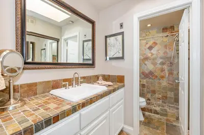 a bathroom with a sink and a toilet and a mirror at 5N-64 Beachfront On the Strand in Oceanside