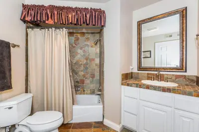 a bathroom with a toilet and a sink and a mirror at 5N-64 Beachfront On the Strand in Oceanside