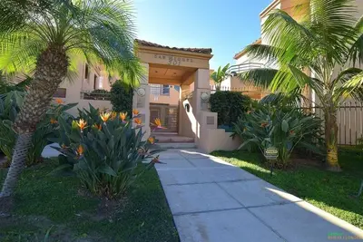 a house with palm trees and a sidewalk at 501P-12 Spectacular Ocean Views Pet Friendly in Oceanside