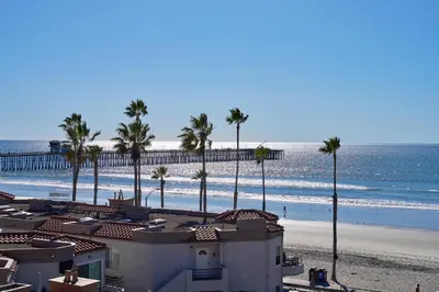 a view of a beach with palm trees and a building at 501P-12 Spectacular Ocean Views Pet Friendly in Oceanside