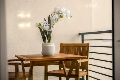 a wooden table with a vase of flowers on it at Luxury 1BR Newport Beach Condo with Pool and Gym in Newport Beach