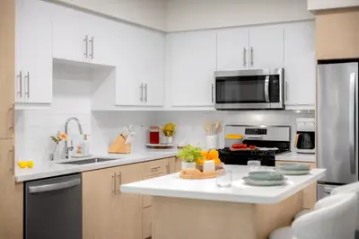 a kitchen with white cabinets and a white counter top at Luxury 1BR Newport Beach Condo with Pool and Gym in Newport Beach