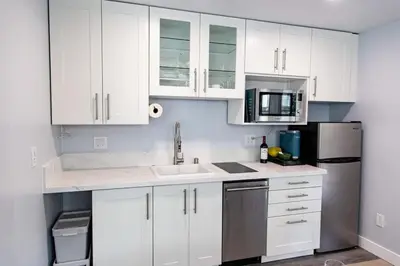 a kitchen with white cabinets and a sink and a microwave at Charming Private Mission Bay Studio 1 in San Diego