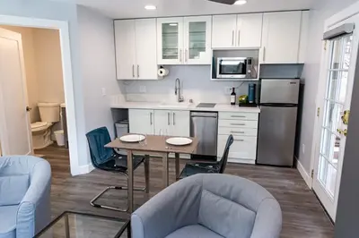 a kitchen with white cabinets and a table and chairs at Charming Private Mission Bay Studio 1 in San Diego