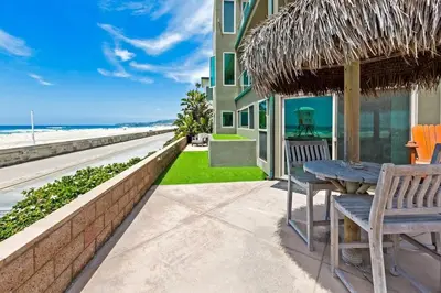 a patio with a table and chairs and the beach at Family Ocean Front 3BR with Parking in San Diego