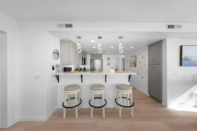 a kitchen with a counter and stools in a room at Family Ocean Front 3BR with Parking in San Diego