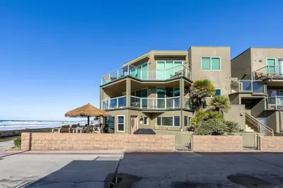 a large apartment building with the ocean in the background at Family Ocean Front 3BR with Parking in San Diego