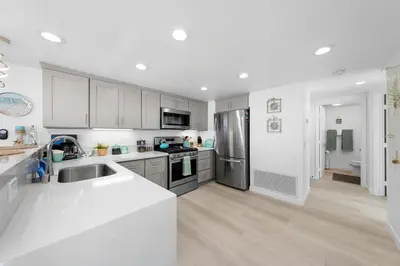 a kitchen with white cabinets and stainless steel appliances at Family Ocean Front 3BR with Parking in San Diego