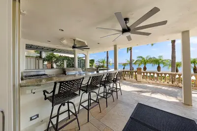 a patio with a bar with chairs and a view of the ocean at Family Luxurious Waterfront Escape in San Diego