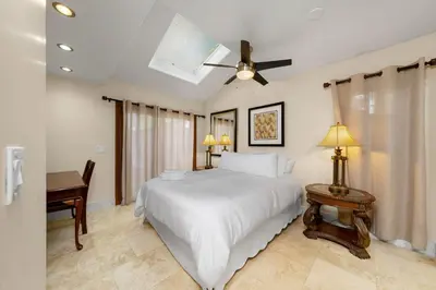 a bedroom with a white bed and a desk at Family Luxurious Waterfront Escape in San Diego