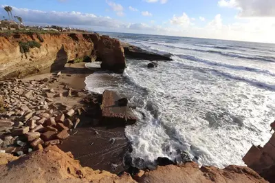 a beach with rocks and the ocean on a sunny day at The Sweet Escape for 2 in San Diego