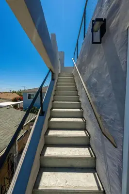 a stairway leading up to a building with a blue sky at Modern Urban Escape Rooftop & Walkable Fun in San Diego
