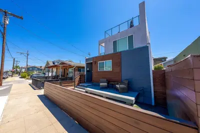 a house on a street with a wooden fence at Modern Urban Escape Rooftop & Walkable Fun in San Diego