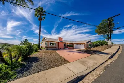 a house with a palm tree and a driveway at Family Hilltop luxe retreat with breathtaking views in La Mesa