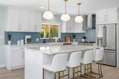 a kitchen with white cabinets and white bar stools at Family Hilltop luxe retreat with breathtaking views in La Mesa