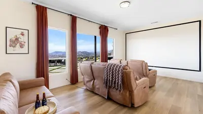 a living room with leather chairs and large windows at Temecula Stay w Pool Movie Room Sauna Tennis Court Panoramic Valley Views Via de Oro Estate by Avantstay in Temecula