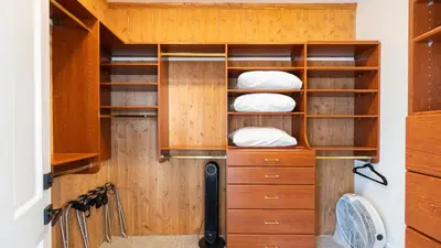 a closet with wooden cabinets and white pillows at Temecula Stay w Pool Movie Room Sauna Tennis Court Panoramic Valley Views Via de Oro Estate by Avantstay in Temecula