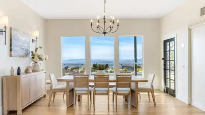 a dining room with a table and chairs and a large window at Temecula Stay w Pool Movie Room Sauna Tennis Court Panoramic Valley Views Via de Oro Estate by Avantstay in Temecula