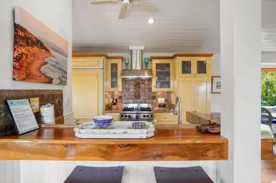 a kitchen with a counter with a stove in it at Darling Del Mar Beach Cottage with Ocean Views in San Diego
