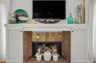 a fireplace with a tv on top of it at Darling Del Mar Beach Cottage with Ocean Views in San Diego