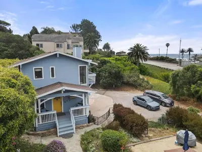 an aerial view of a house with cars parked in a driveway at Darling Del Mar Beach Cottage with Ocean Views in San Diego