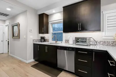 a kitchen with black cabinets and a sink at Relaxing Beach Bungalow in San Diego