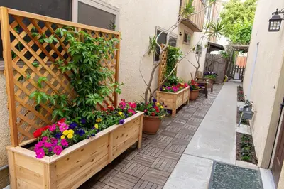 a garden with flowers in wooden planters on a sidewalk at Charming Private Mission Bay Studio 2 in San Diego