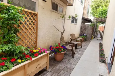 a patio with flowers and chairs and a fence at Charming Private Mission Bay Studio 2 in San Diego