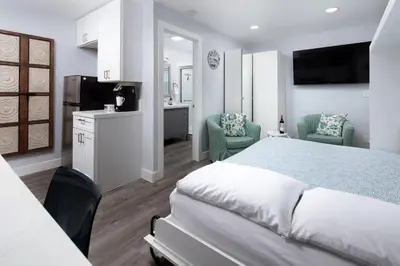 a bedroom with a bed and two chairs and a kitchen at Charming Private Mission Bay Studio 2 in San Diego
