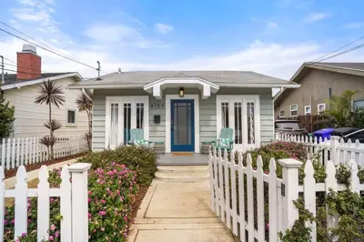 a white fence in front of a house at Bright and Quirky Hillcrest Craftsman in San Diego