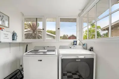 a kitchen with a stove and a sink and windows at Bright and Quirky Hillcrest Craftsman in San Diego