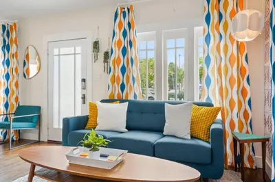 a living room with a blue couch and a table at Bright and Quirky Hillcrest Craftsman in San Diego